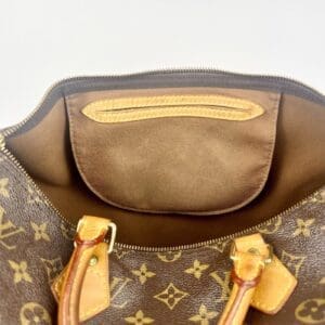 Open brown designer bag with handles.