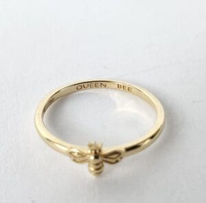 Gold ring with "Queen Bee" engraving.