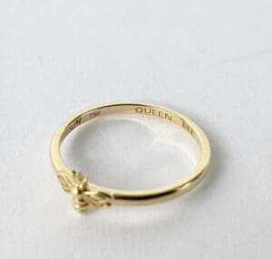 Gold ring with bee design engraving.