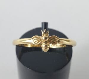 Gold ring with bee and crown design.