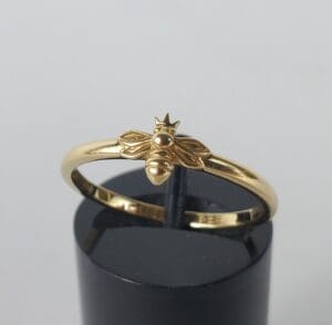 Gold ring with bee and crown design.