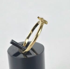 Gold ring with small decorative element.