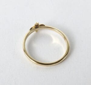 Gold ring with small flower detail.