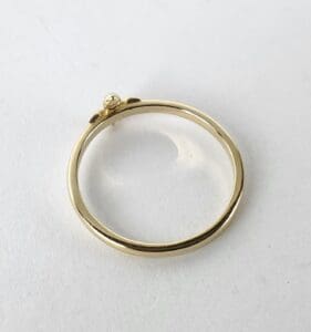 Gold ring on a white surface.