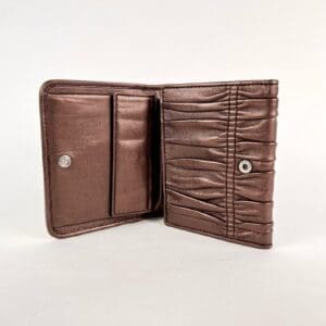 Brown leather wallet with snap buttons open.