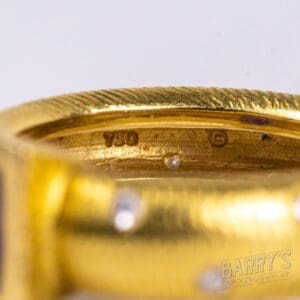Gold ring with "750" hallmark and logo.