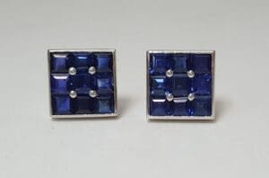 Square blue gemstone earrings on display.