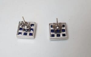 Square earrings with blue and silver design.