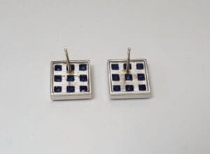 Square earrings with blue square patterns.