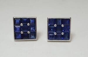 Square blue gemstone earrings on display.