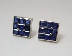 Square earrings with blue gemstones.