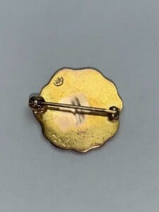 Gold brooch back with clasp and stamp.