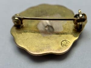 Back of a gold floral brooch.