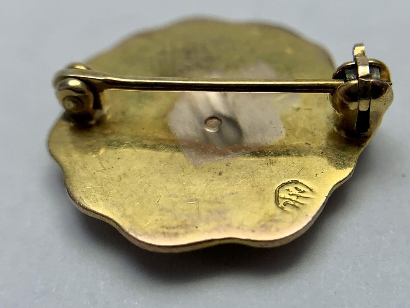 Back of a gold floral brooch.