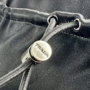 Prada drawstring detail on black fabric.