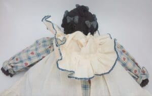 Back view of doll in checkered dress.