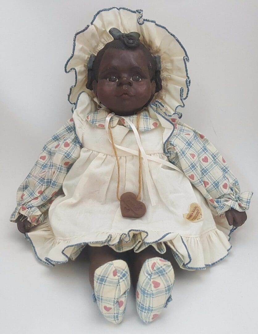Vintage doll in bonnet and patterned dress.