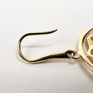 Gold earring with a hook design.