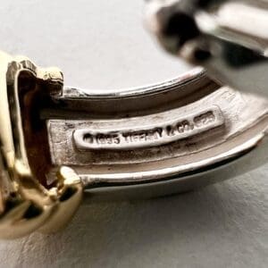Gold and silver ring with engraved text.