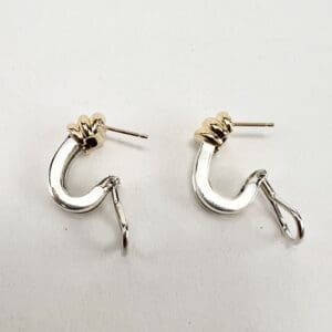 Gold and silver hook earrings on display.