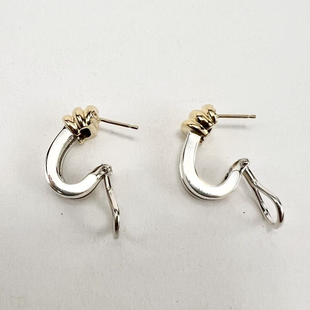 Gold and silver hook earrings on display.