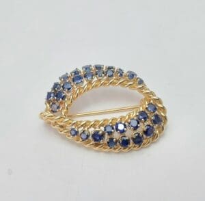 Gold brooch with blue gemstones.