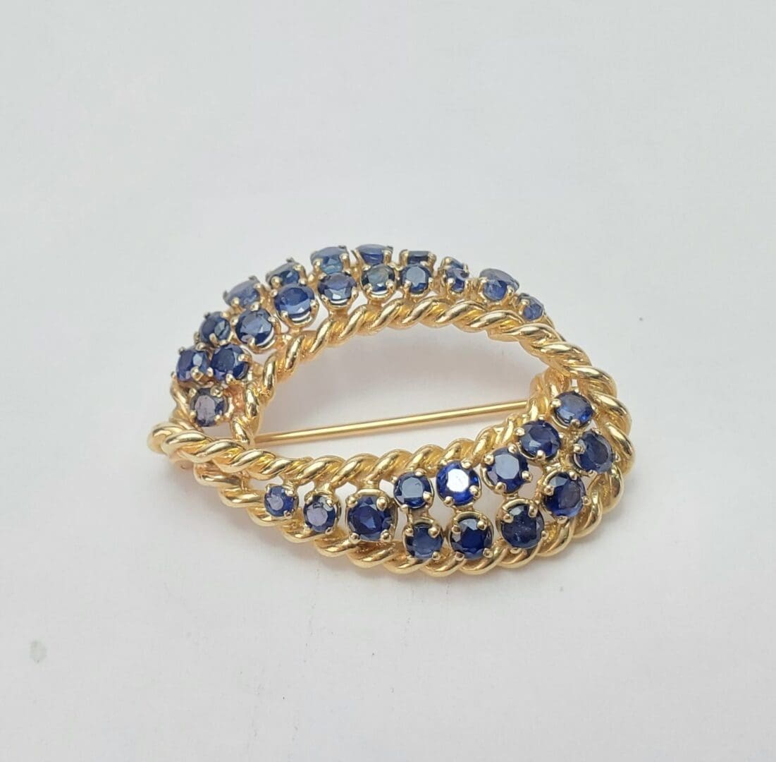 Gold brooch with blue gemstones.