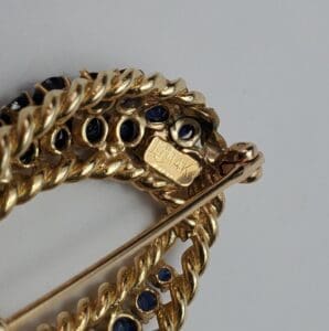 Gold brooch with blue gemstones, marked 14K.