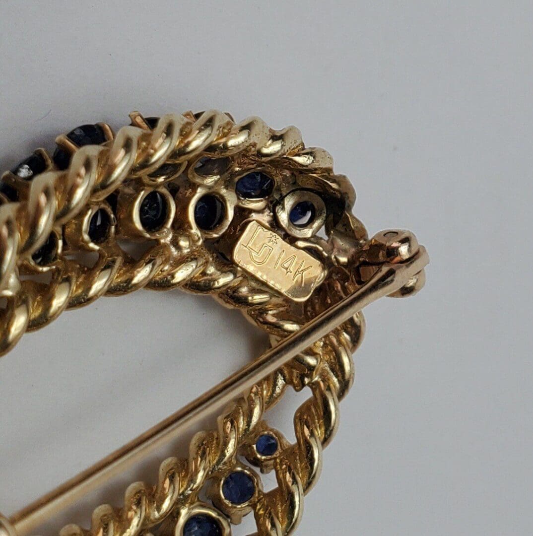 Gold brooch with blue gemstones, marked 14K.