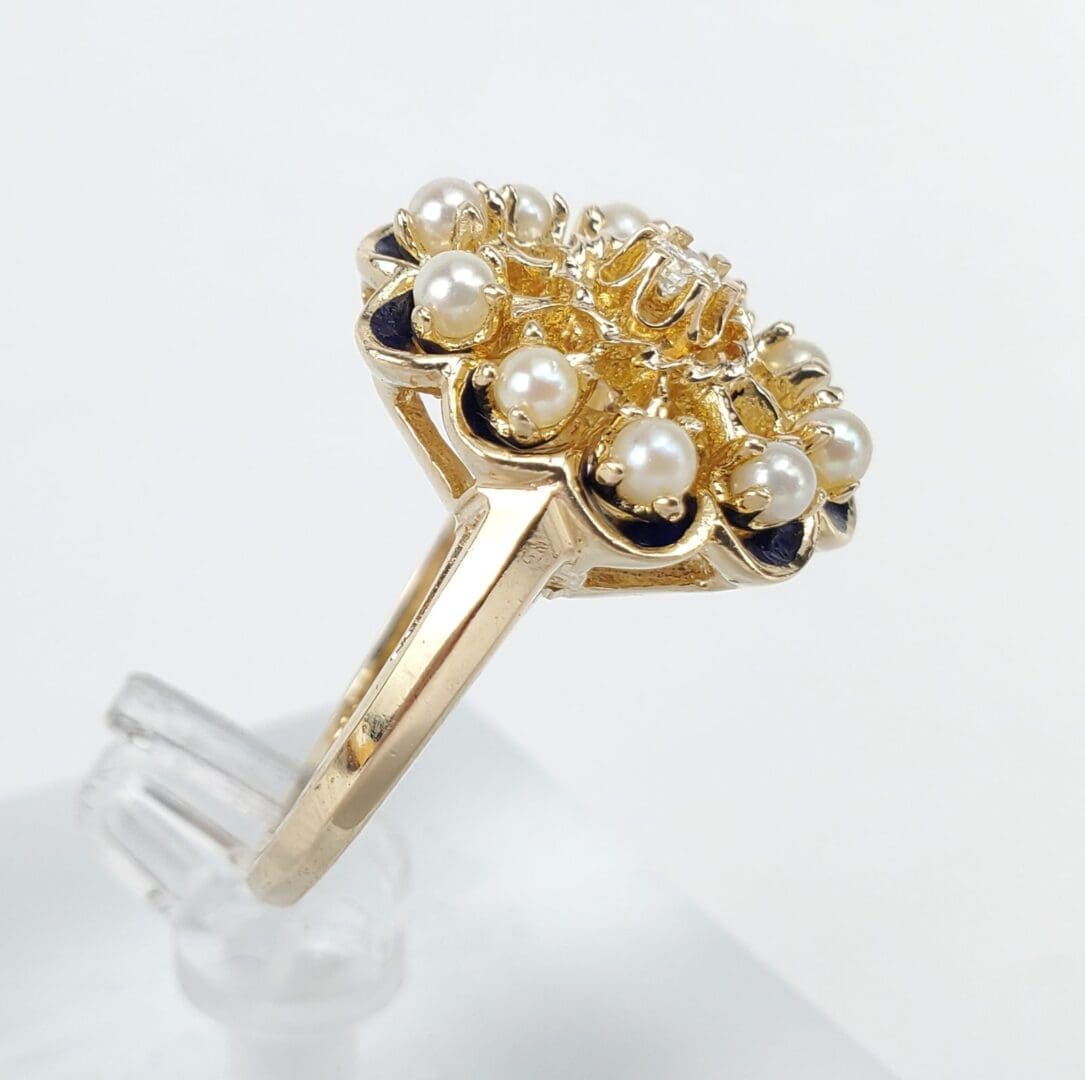Gold ring with pearls and dark stones.