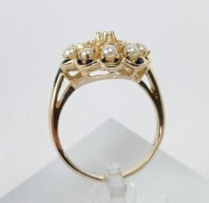 Gold ring with pearls and intricate design.