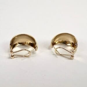 Gold clip-on earrings on white background.