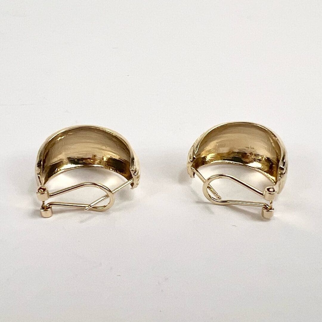 Gold clip-on earrings on white background.