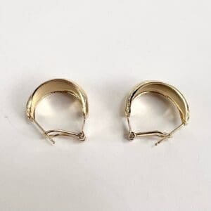 Gold hoop earrings on white background.
