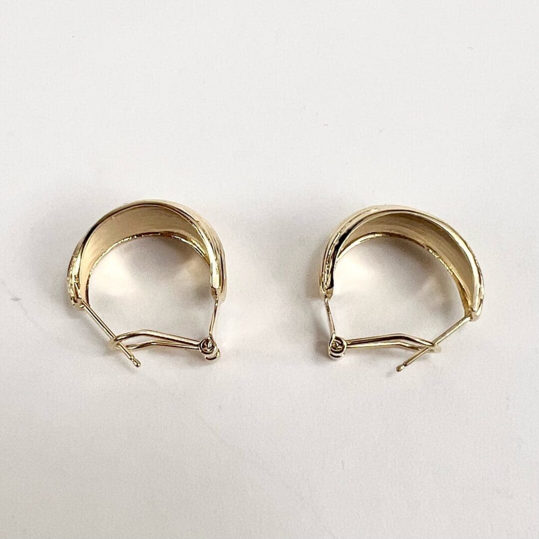 Gold hoop earrings on white background.