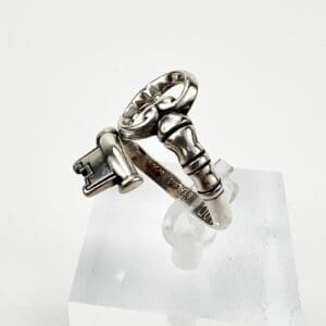 Silver ring with key and lock design.