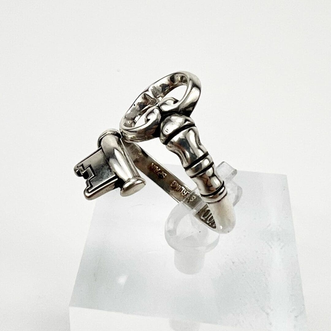 Silver ring with key and lock design.