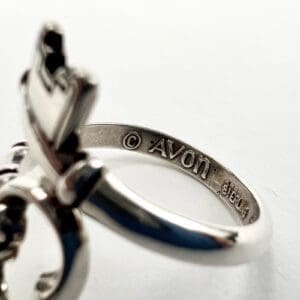 Silver ring with engraved Avon logo.