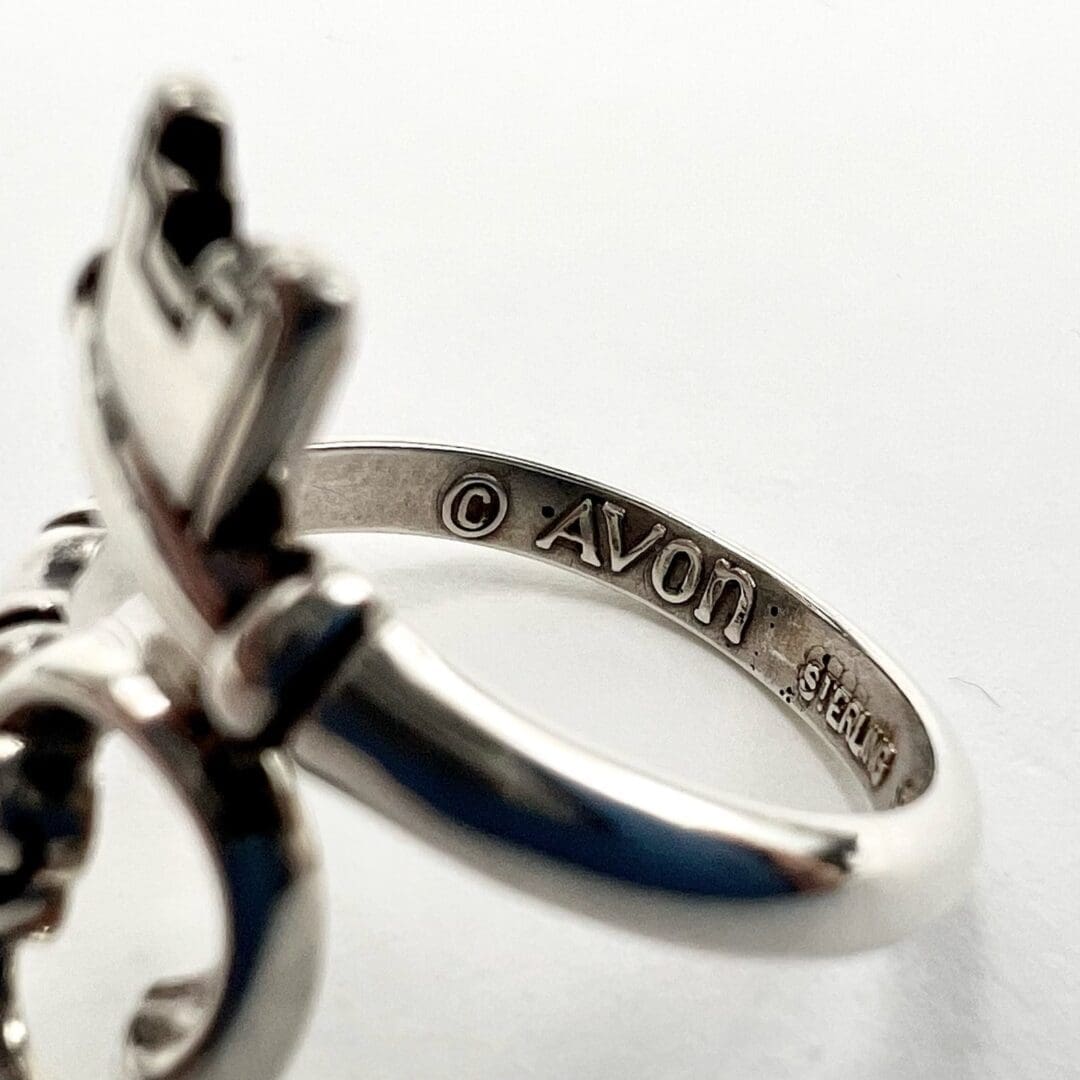 Silver ring with engraved Avon logo.