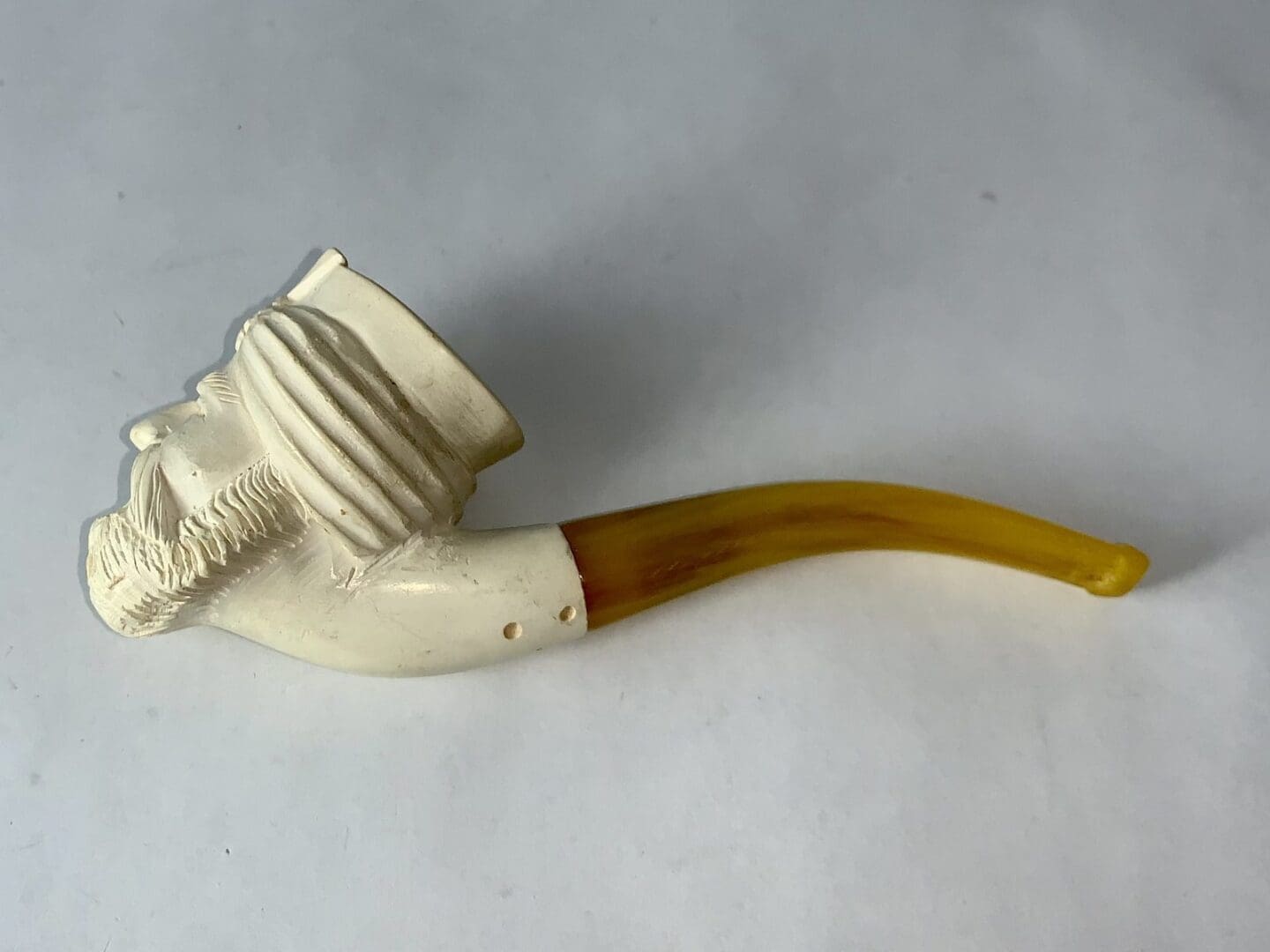 Carved pipe with a bearded face design.