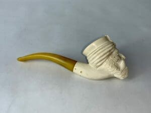 Carved pipe with a bearded face design.
