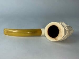 White pipe with yellow stem on table.