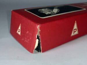 Red box with a torn corner.