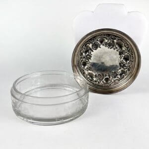 Glass bowl with ornate silver lid.