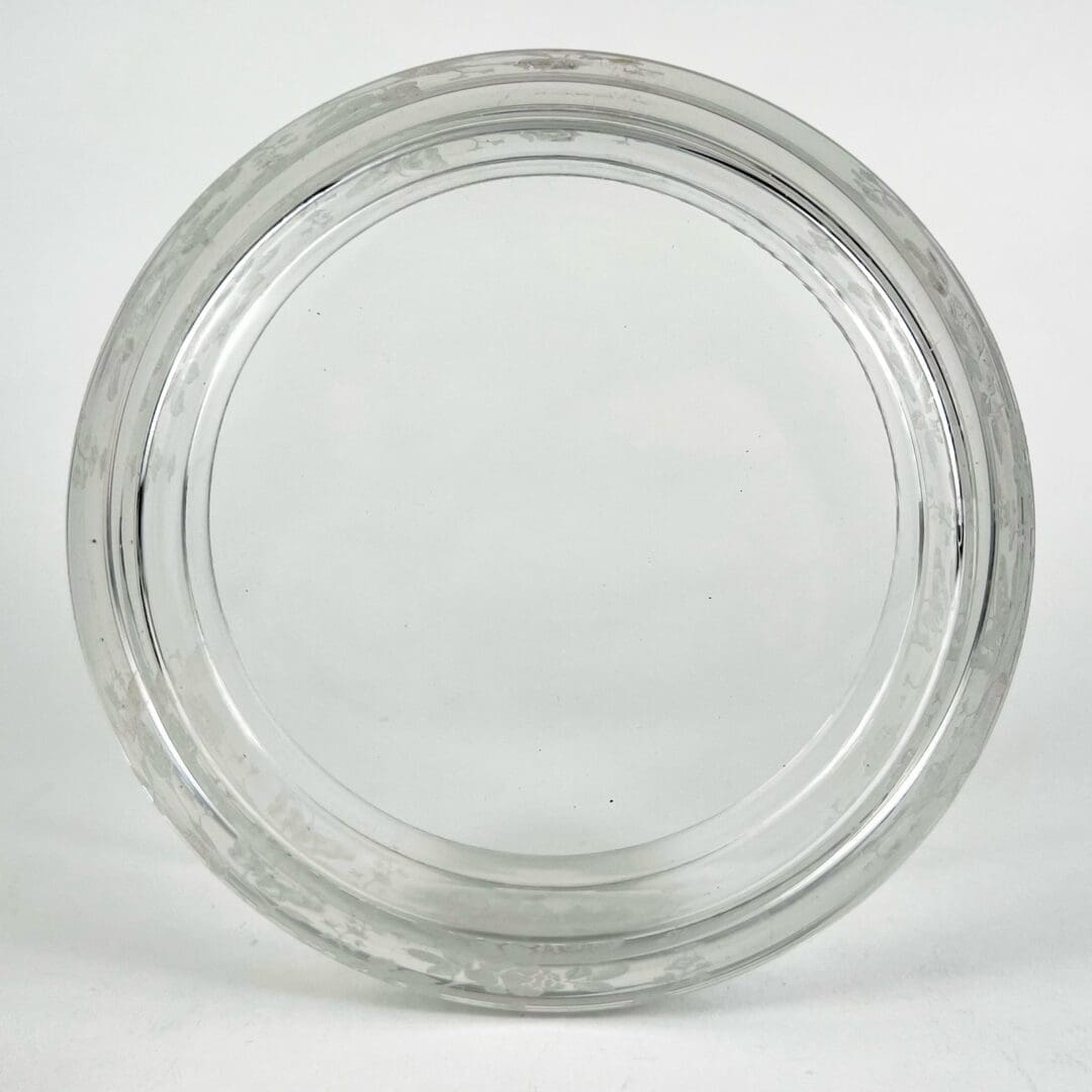 Clear glass jar lid on white background.