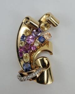 Gold brooch with colorful gemstones and diamonds.