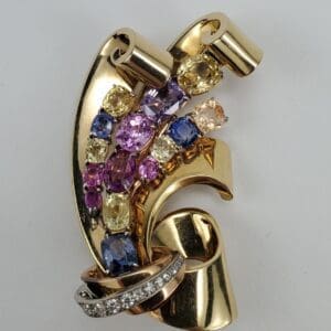 Gold brooch with colorful gemstones and diamonds.