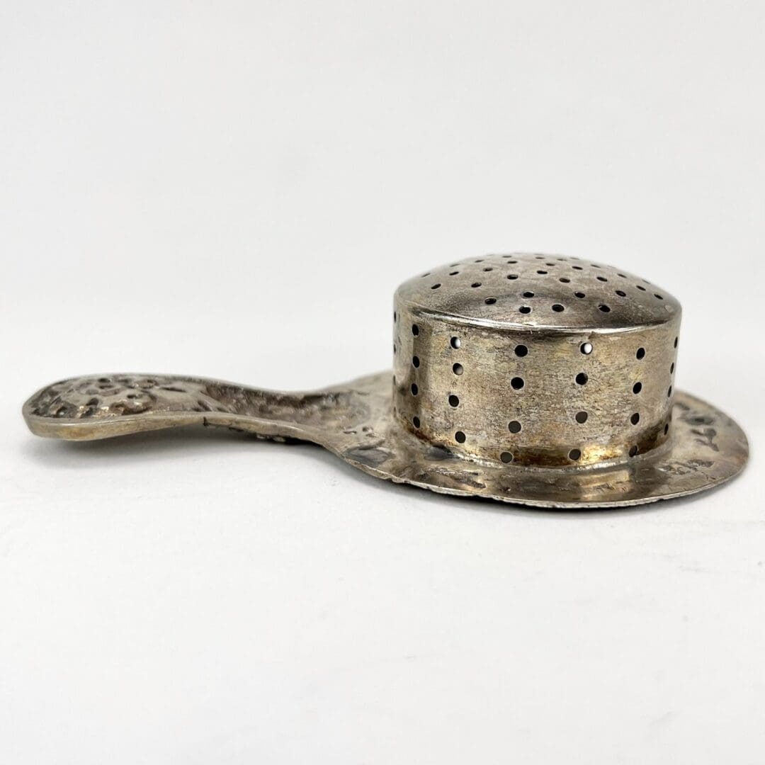 Vintage metal tea strainer with handle.