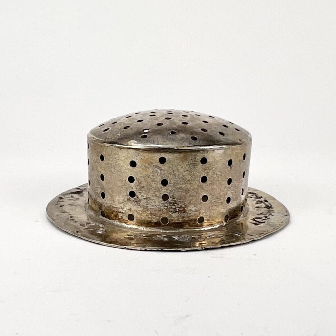 Metal hat-shaped object with ventilation holes.