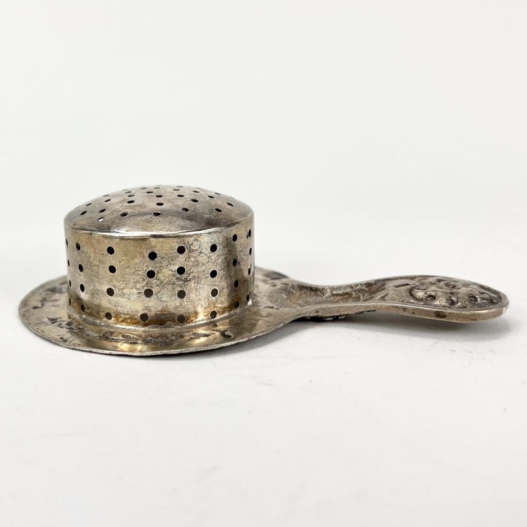 Antique silver tea strainer with handle.